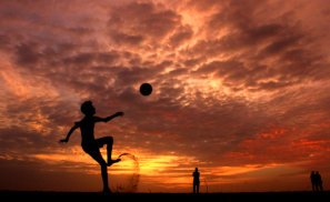 silhoutte of a young boy playing soccer